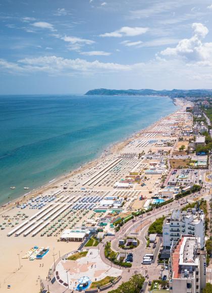 Überfüllter Strand mit Strandresorts, Luftaufnahme einer Küstenstadt.