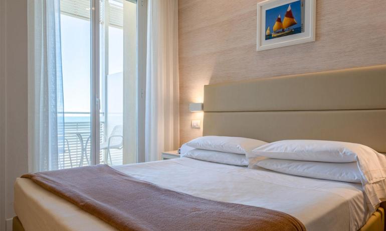Schlafzimmer mit Balkon und Meerblick, moderne und gemütliche Einrichtung.