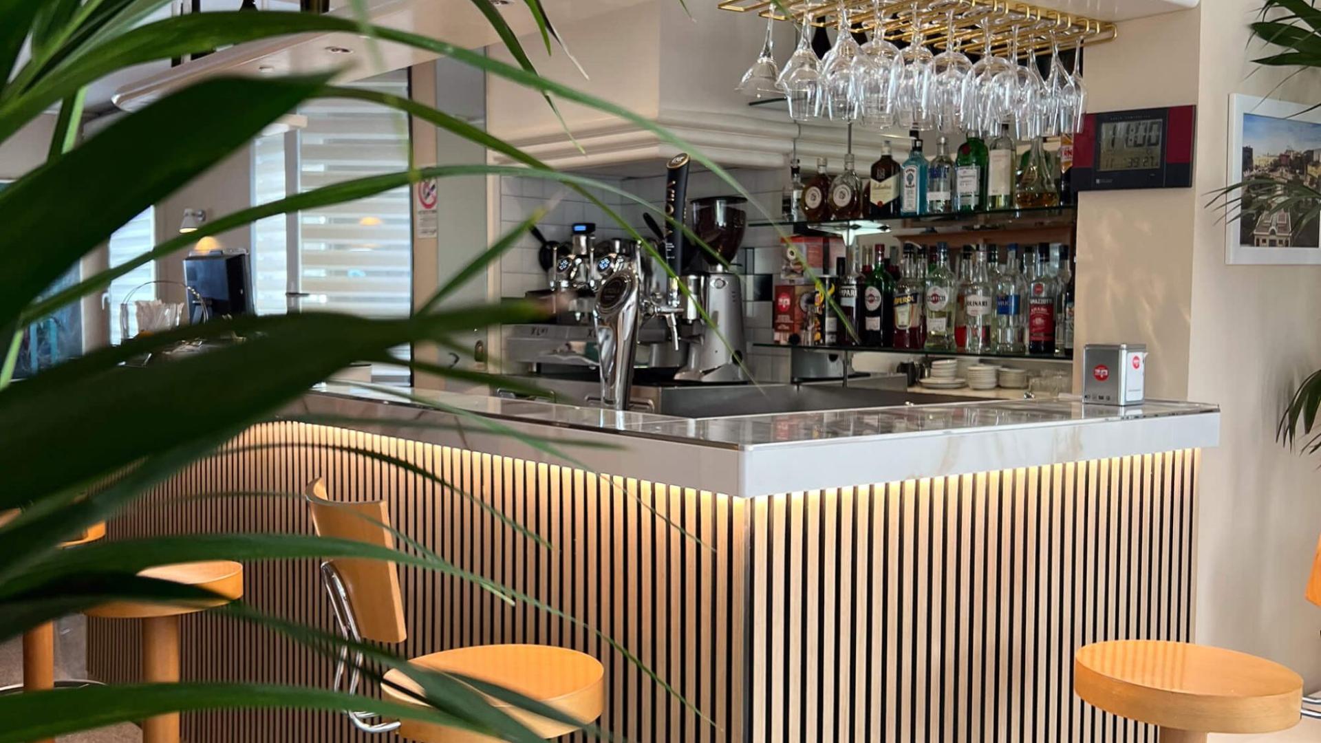 Elegante bar moderno con sedie alte e bottiglie esposte.