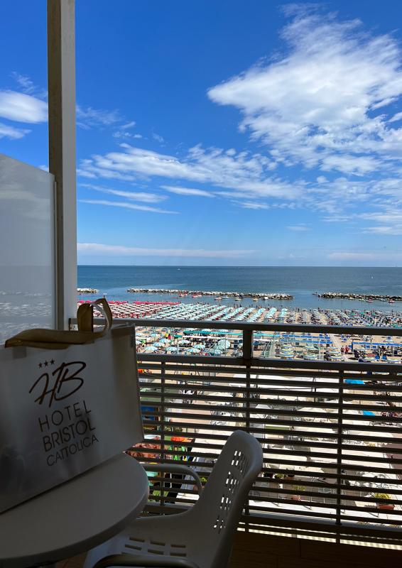 Meerblick vom Hotel mit bunten Strandsonnenschirmen.